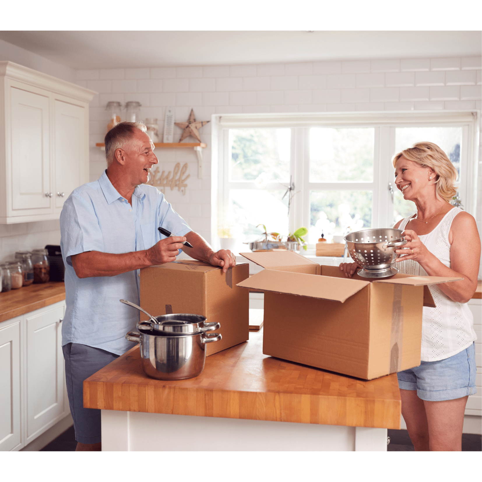 Couple in kitchen packing boxes